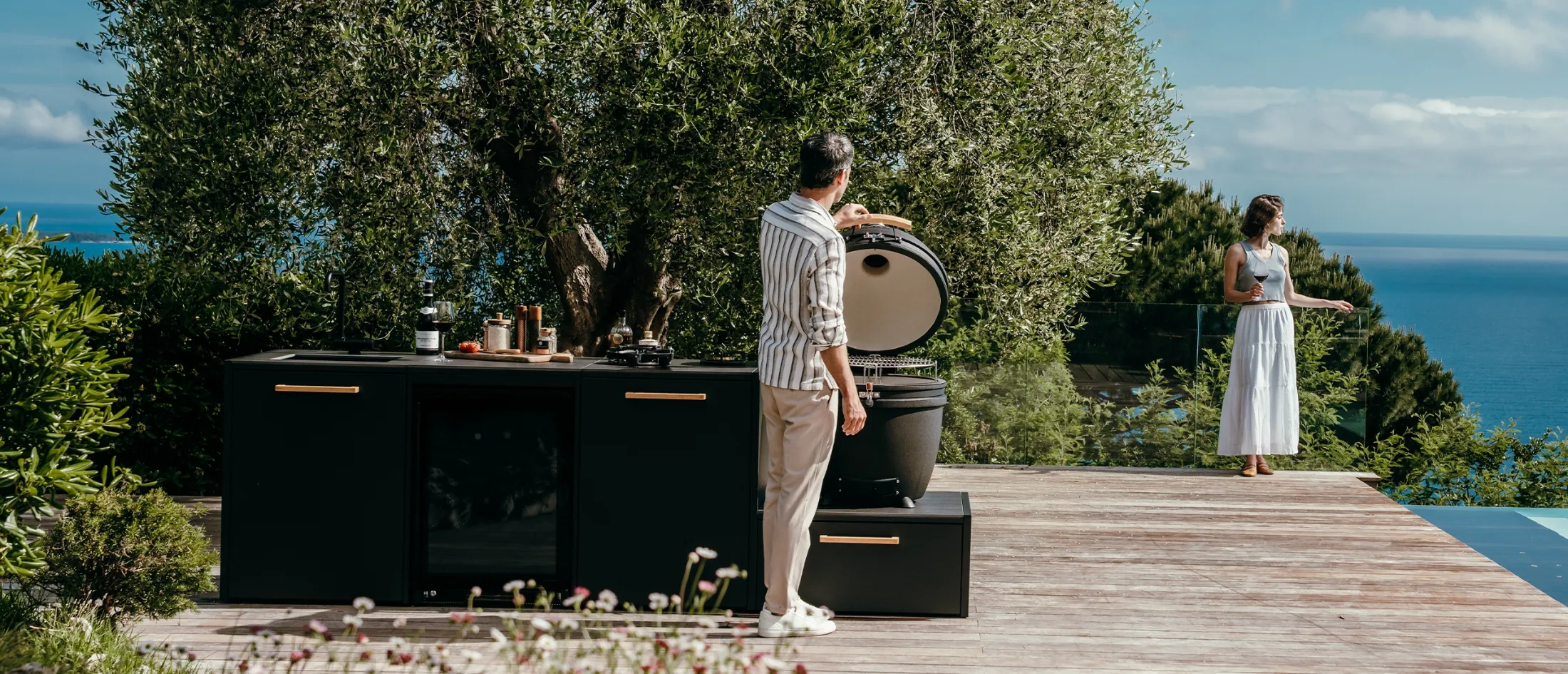Buitenkeuken op terras met kamado en uitzicht op zee