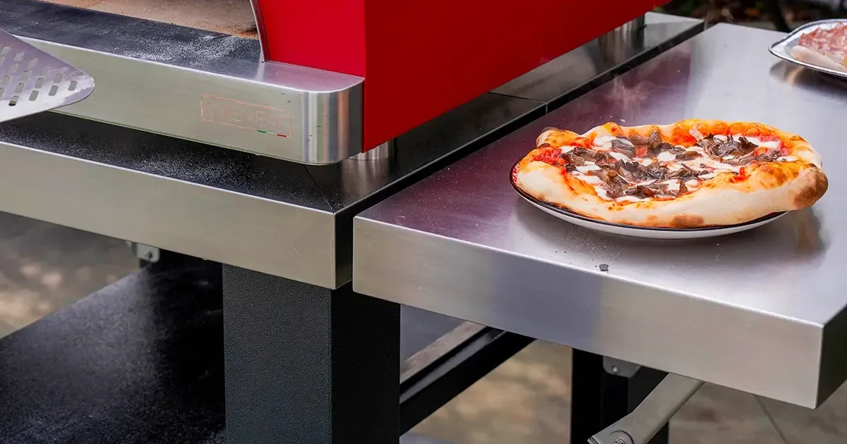 Pizza op de inklapbare RVS zijtafel van het Oveneat verrijdbaar onderstel